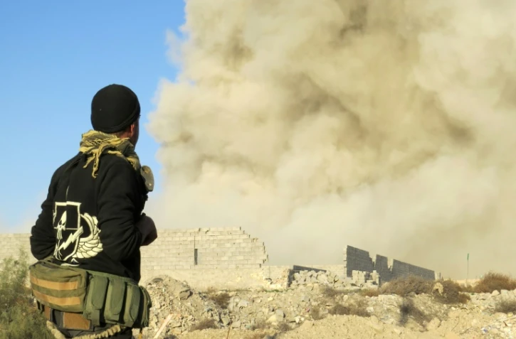 Un membre des forces progouvernementales irakiennes regarde la fumée s'élever de Ramadi, à 110 km à l'ouest de Bagdad, le 27 décembre 2015