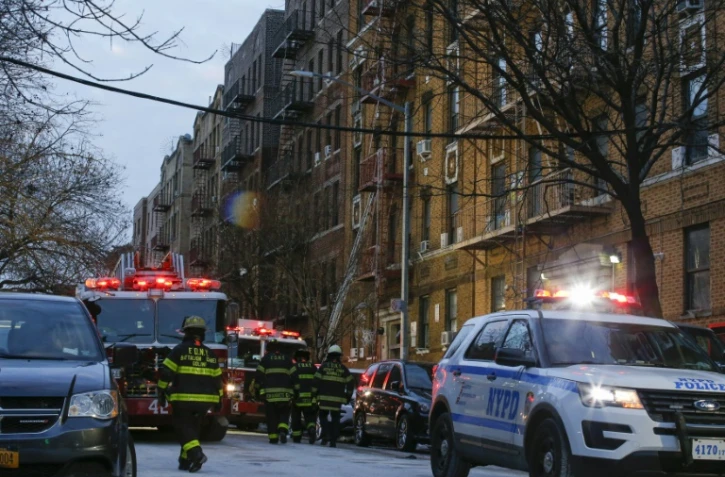 Des pompiers new-yorkais s'activent encore le 29 décembre 2017 au matin devant l'immeuble ravagé à New York par un incendie meurtrier