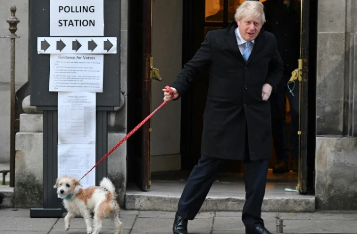 Boris Johnson et son chien Dilyn quittent le bureau de vote, à Londres le 12 décembre 2019