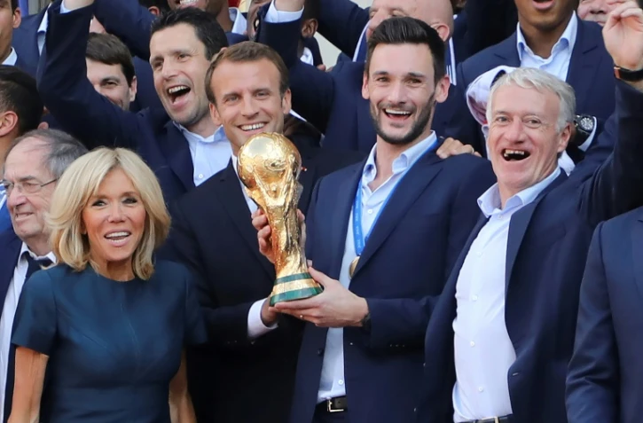 Le président Emmanuel Macron avec le capitaine des Bleus Hugo Lloris brandissent le trophée de champions du monde à l'Elysée, lors d'une réception le 16 juillet 2018
