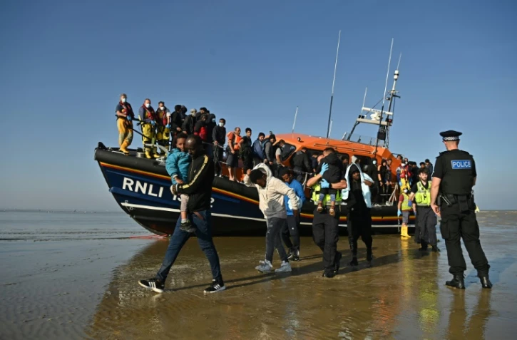 Des migrants escortés par le secours en mer britannique débarquent d'un bateau à Dungeness, le 7 septembre 2021, dans le sud-est de l'Angleterre