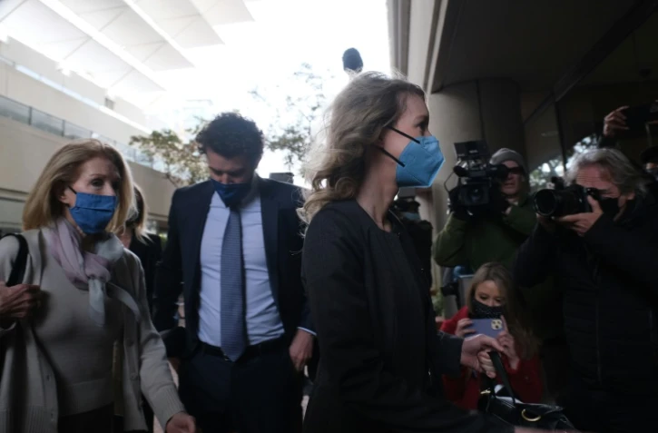Elizabeth Holmes (d) arrive au tribunal de San José, en Californie, accompagnée de son compagnon Billy Evans (c) et de sa mère, le 3 janvier 2022