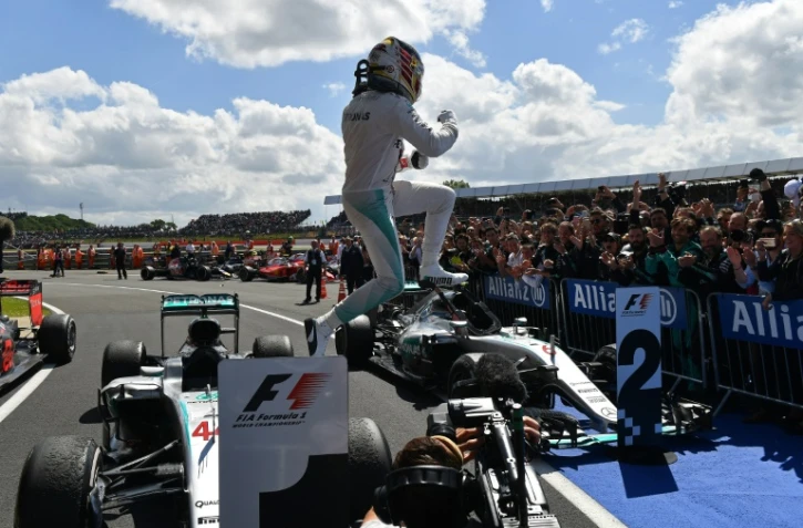 Le Britannique Lewis Hamilton saute de sa Mercedes après sa victoire au GP de Grande-Bretagne sur le circuit de Silverstone, le 10 juillet 2016