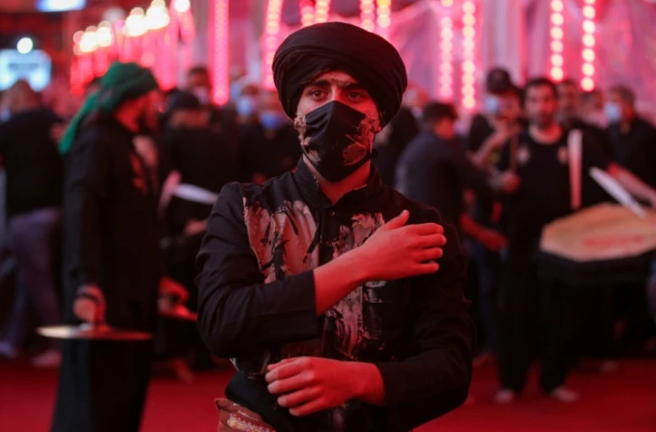 Un fidèle chiite portant un masque de protection participe à un rituel commémorant le martyre de l'imam Hussein, dans son mausolée à Kerbala, dans le centre de l'Irak, le 29 août 2020