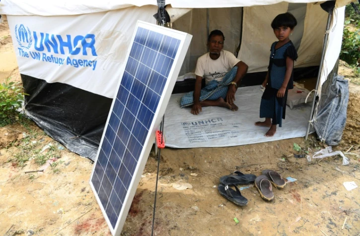 Des réfugiés Rohingyas attendent qu'une lanterne se charge grâce à l'énergie solaire, dans un camp de Kutupalong au Bangladesh, le 7 octobre 2017
