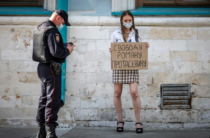 Une jeune femme brandit une pancarte "Liberté pour Roman Protassevitch" devant l'ambassade du Bélarus à Moscou le 25 mai 2021