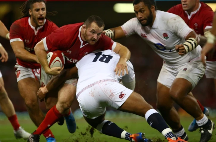 Le Gallois Ken Owens (2e g) taclé par l'Anglais Kyle Sinckler (c) lors du test-match à Cardiff, le 17 août 2019