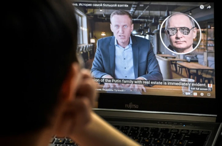 Une femme regarde la vidéo du leader de l'opposition emprisonné Alexei Navalny, accusant le président Poutine de corruption, à Moscou, le 21 janvier 2021