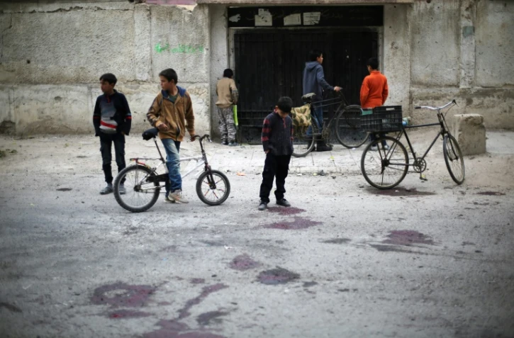 Des enfants sur le site d'un bombardement du régime qui a tué au moins quatre écoliers selon l'OSDH, le 31 octobre 2017 à Jisrine en Syrie