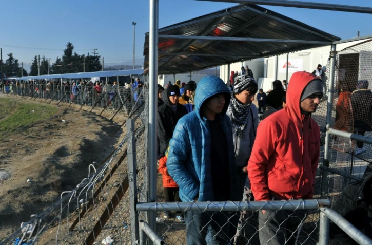 Des migrants en attente de distribution de nourriture le 21 janvier 2016 près d'Idomeni à la frontière entre la Grèce et la Macédoine
