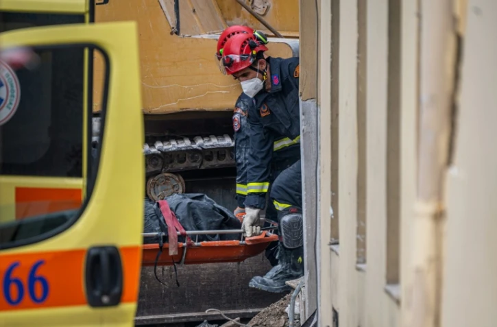 Des secouristes transportent le corps d'une personne retrouvée sous les décombres après l'effondrement d'un immeuble à Athènes, le 26 septembre 2026 