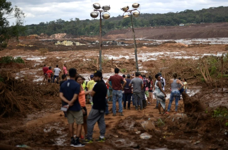Des habitants contemplent l'étendue du désastre au lendemain de la rupture d'un barrage minier ayant fait au moins 37 morts et 300 disparus dans l'est du Brésil, le 26 janvier 2019.