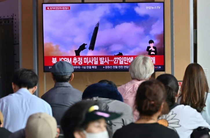 Des personnes regardent un écran de télévision diffusant un bulletin d'information sur un test de missile nord-coréen, dans une gare de Séoul, le 12 juillet 2023