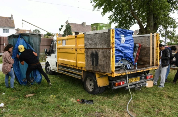 Des bénévoles de l'association "L'Auberge des Migrants" installe une douche mobile pour les migrants et réfugiés à Calais, le 5 septembre 2017