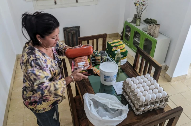 La Cubaine Maria Paez range la nourriture envoyée depuis Miami par ses enfants exilés, le 16 mai 2024 à La Havane