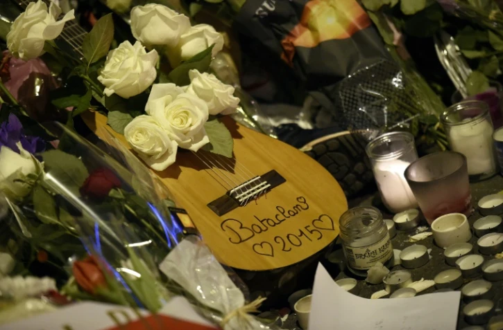 Des fleurs, une guitare et des bougies sont déposées le 15 novembre 2015 en face du Bataclan à Paris en mémoire des victimes des attentats