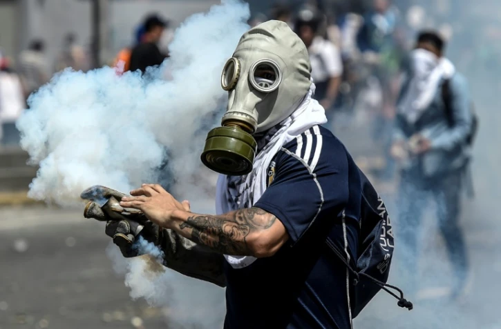 Un opposant vénézuélien porte un masque à gaz lors de heurts avec la police, le 6 avril 2017 à Caracas
