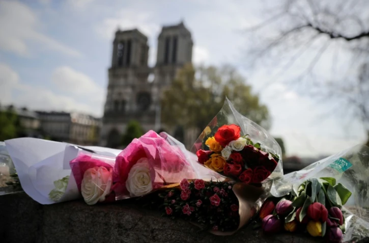 Des fleurs déposées sur le Pont Saint Michel, devant Notre-Dame, deux jours après l'incendie qui a ravagé la cathédrale, le 17 avril 2019
