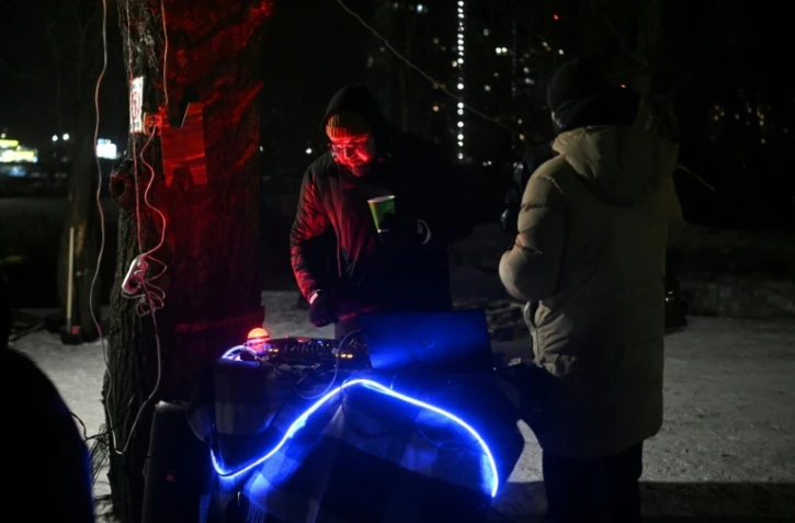 Un DJ anime une fête improvisée par des habitants dans le froid polaire à Kiev, le 18 janvier 2026