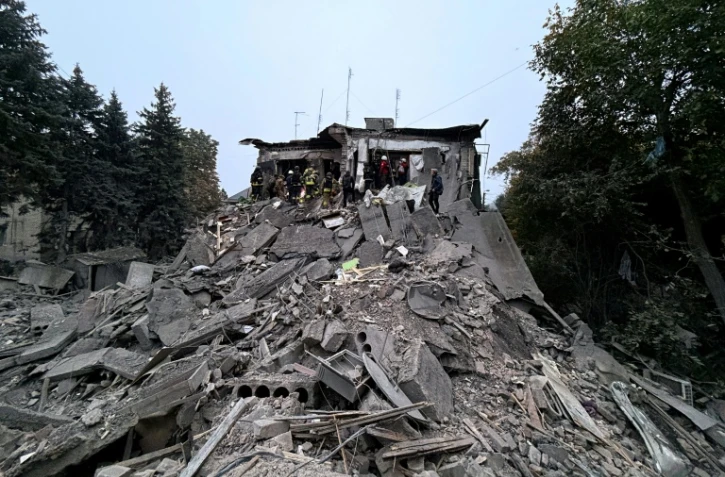 Des secouristes ukrainiens travaillent dans les décombres d'un immeuble de Zaporijjia, dans le sud-est de l'Ukraine, touché par une frappe russe le 10 octobre 2026