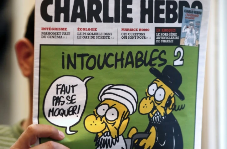 Un homme lit le 19 septembre 2012 le numéro de Charlie Hebdo paru ce jour-là , montrant un juif et un musulman sous le titre "Intouchables 2"