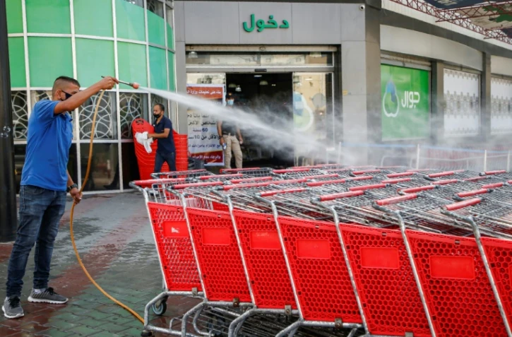 Un employé d'un supermarché palestinien désinfecte des chariots à Gaza le 21 septembre 2020