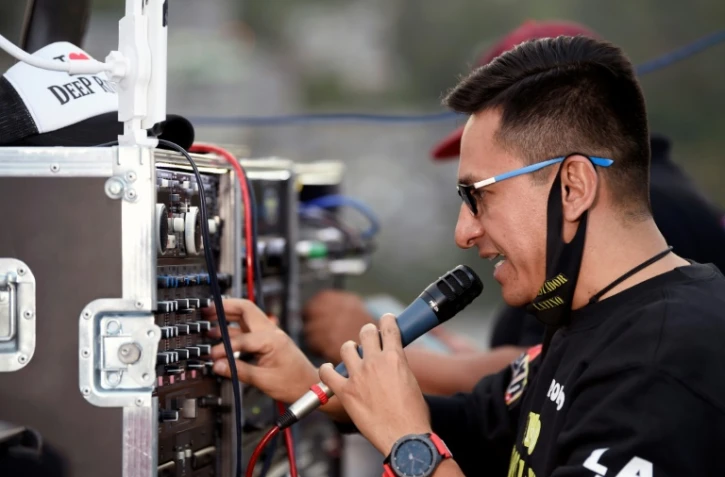 Le DJ Mexicain Roberto Garcia teste son micro avant de commencer son show sur une toit du quartier de Rio Hondo, un quartier de Naucalpan de Juarez, près de Mexico, le 18 juillet 2020
