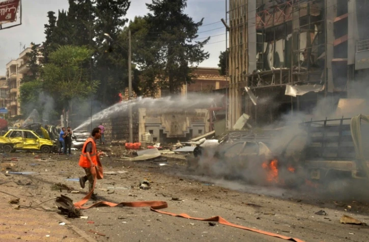 Des secouristes devant un hôpital touché par un bombardement dans un quartier du nord d'Alep, le 3 mai 2016