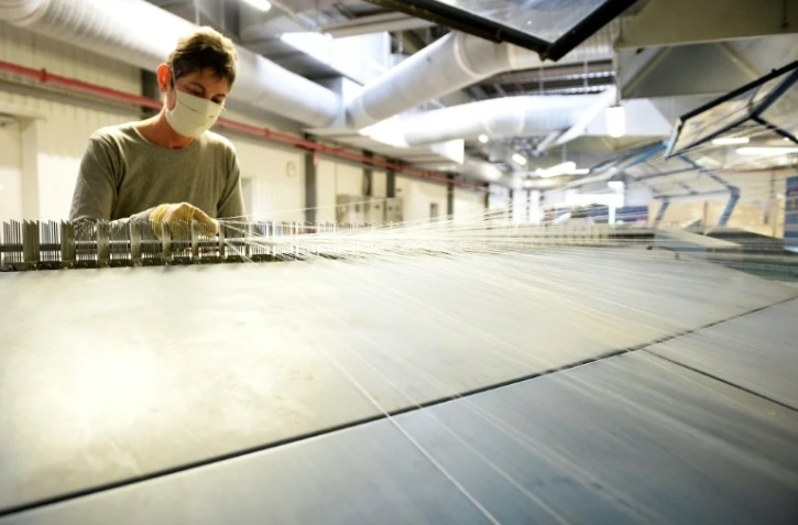 Une employée de l'usine Tenthorey travaille sur un métier à tisser, le 11 juin 2020 à Eloyes, dans les Vosges