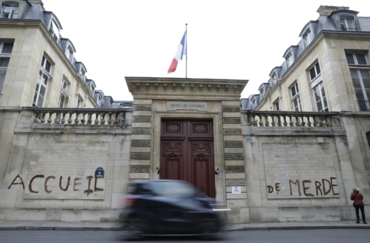 Des militants d'associations de défense des migrants ont tagué "accueil de merde" sur la façade du ministère du Logement à Paris le 16 décembre 2017 pour dénoncer les conditions de réception des migrants en France