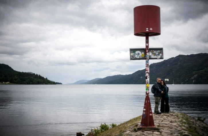 Des visiteurs se prennent en photo devant le Loch Ness, le 6 juillet 2023 en Ecosse