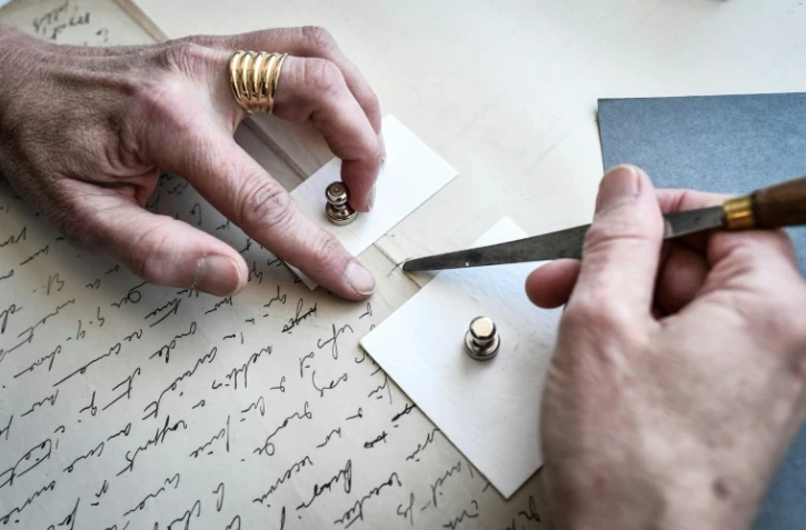 Une conservatrice de la Bibiliothèque nationale de France travaille sur une déchirure dans un manuscrit de Marcel Proust, à Paris le 8 juillet 2022
