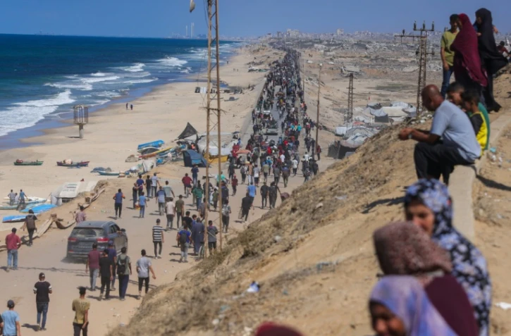 Des Palestiniens en marche sur la route al-Rachid en direction de la ville Gaza, après l'annonce du cessez-le-feu dans la bande de Gaza,  le 10 octobre 2025.

