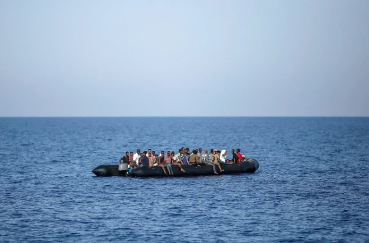 Des migrants attendent d'être secourus par les garde-côtes italiens près des côtes libyennes, le 6 août 2017