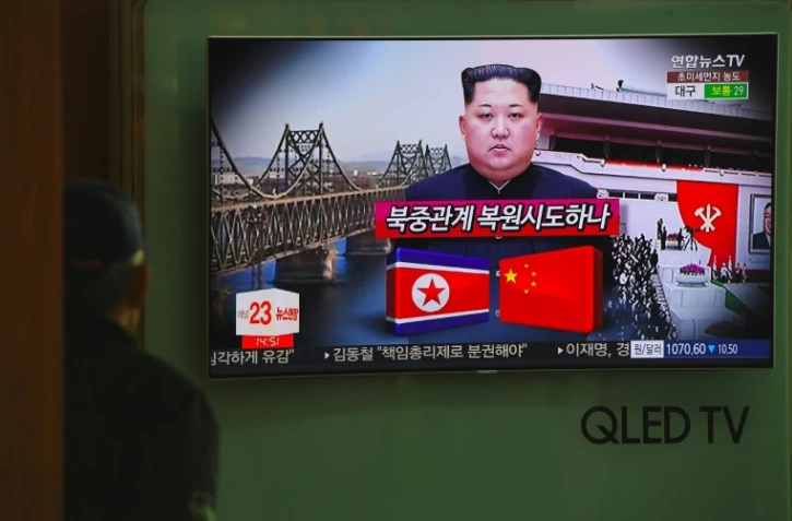 Un passant regarde à la télévision dans une gare de Séoul le 27 mars 2018 des informations évoquant une possible visite en Chine du dirigeant nord-coréen Kim Jong Un