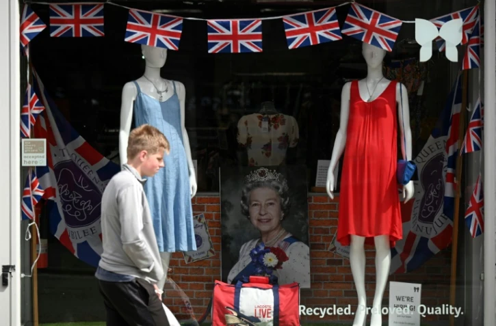 Passant devant une vitrine décorée à l'occasion du jubilé de platine d'Elizabeth II, à Colchester dans l'est de l'Angleterre, le 31 mai 2022