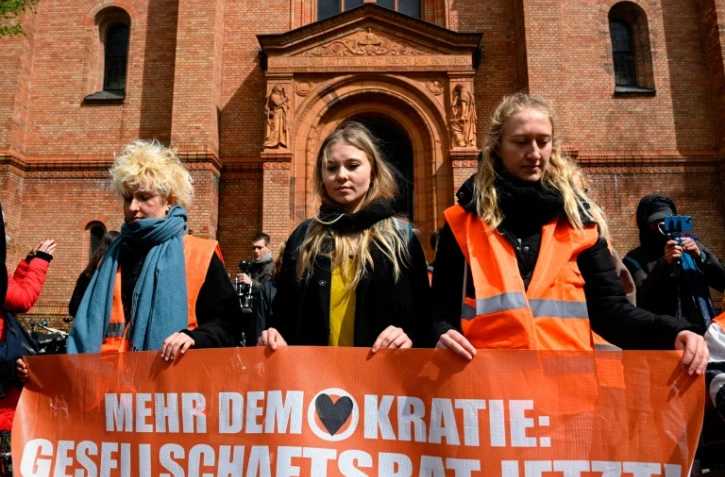 Des militants du groupe écologiste "Dernière génération" devant l'église Saint Thomas à Berlin, le 26 avril 2023