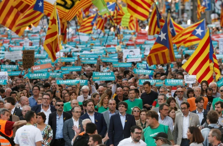Des dizaines de milliers d'indépendantistes catalans, le président du gouvernement catalan Carles Puigdemont (c) en tête, manifestent le 21 octobre 2017 à Barcelone