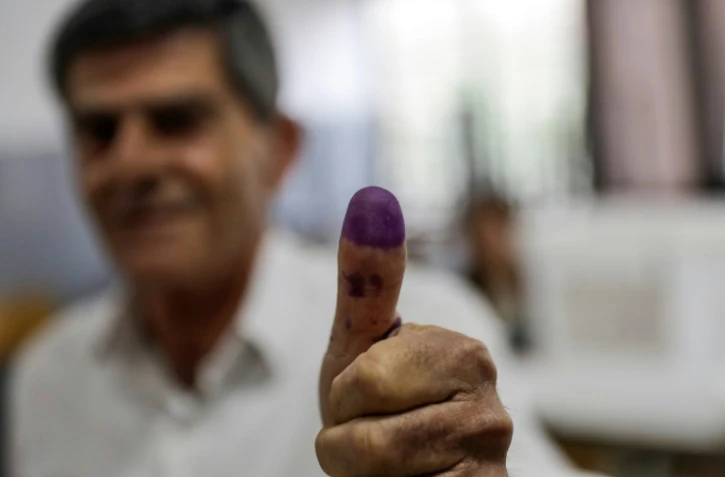Un électeur libanais montre son pouce teinté d'encre après avoir voté lors des premières législatives depuis 2009, à Byblos, le 6 mai 2018