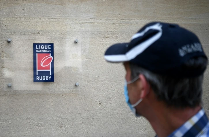 Un homme masqué devant le siège de la Ligue nationale de rugby à Paris le 28 avril 2020