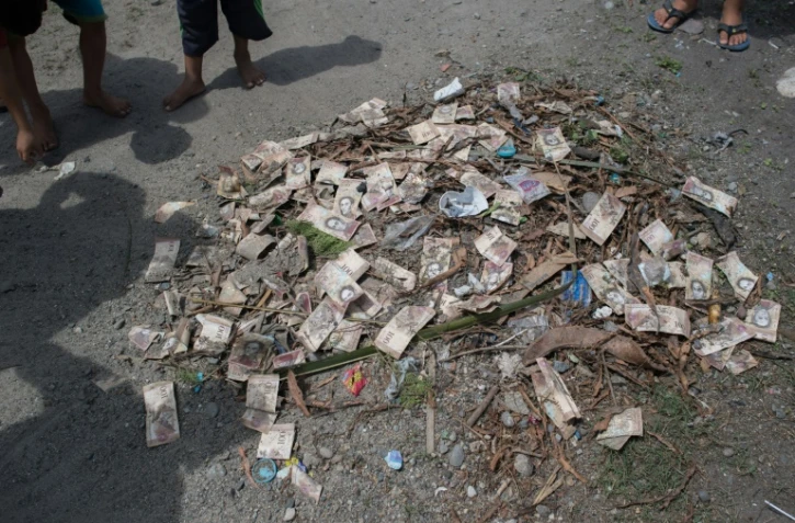 Des billets de bolivars empilés parmi des détritus à Puerto Concha, au Vénézuela, le 8 septembre 2021.