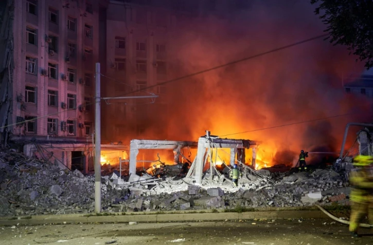Des pompiers luttent contre un incendie dans un bâtiment après une frappe russe, le 28 juillet 2023 à Dnipro, en Ukraine