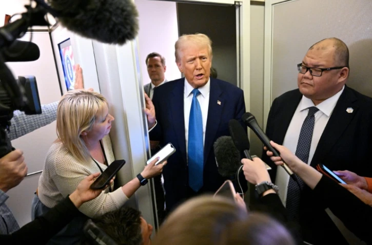 Le président américain Donald Trump parle à des journalistes à bord de l'avion présidentiel, le 19 février 2025