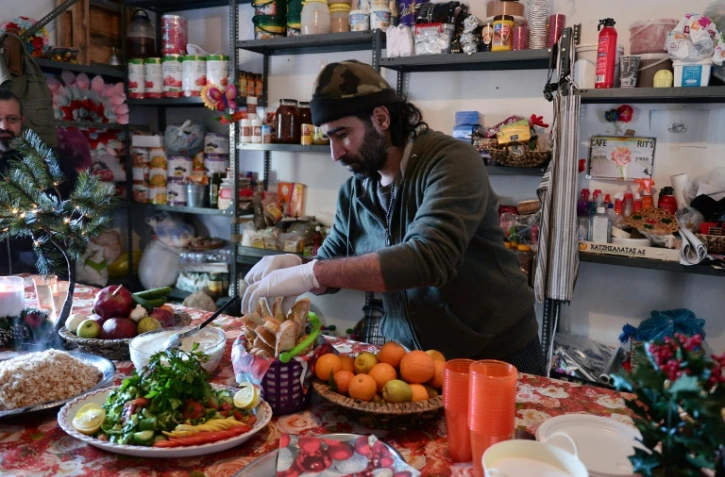 Le chef cuisinier syrien Talal Rankoussi (c) prépare un repas pour les réfugiés du camp de Ritsona, au nord d'Athènes, le 21 décembre 2016 en Grèce