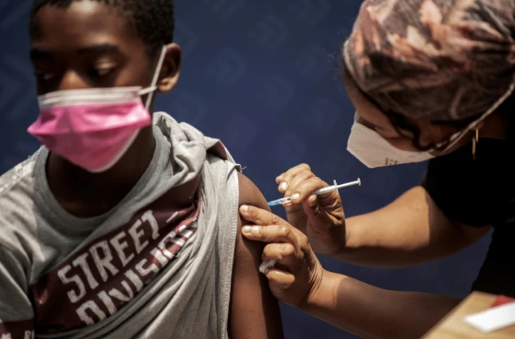Un jeune garçon reçoit une dose du vaccin anti-Covid-19 Pfizer/BioNTech au centre de vaccination Discovery à Johannesburg, le 15 décembre 2021
