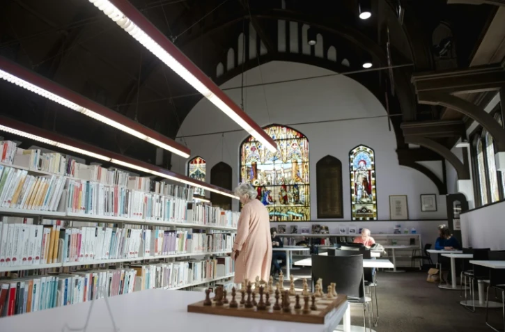Des personnes visitent la bibliothèque Mordecai-Richler construite dans une église anglicane réaménagée dans l'arrondissement du Mile-End à Montréal, le 26 septembre 2023. 