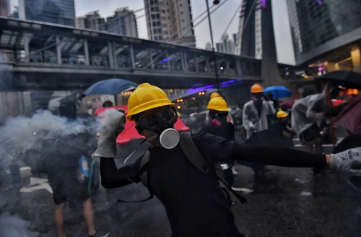 Des manifestants retournent des gaz lacrymogènes contre la police dans la banlieue de Tsuen Wan à Hong Kong le 25 août 2019