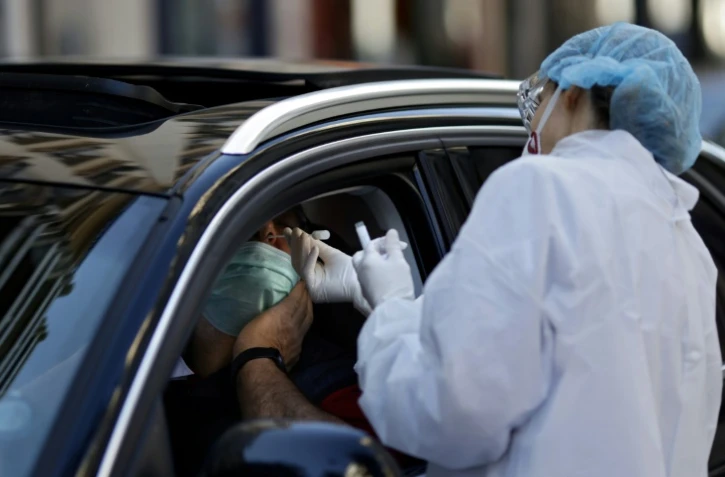 Une biologiste effectue un prélèvement pour un test du coronavirus dans un drive à Neuilly-sur-Seine, le 22 avil 2020 près de Paris
