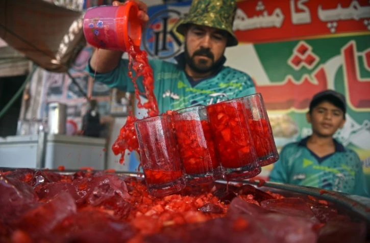 Un vendeur sert des boissons Rooh Afza en bordure de route à Karachi, au Pakistan, le 25 mai 2022