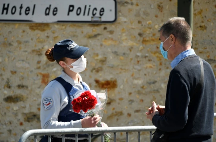 Un homme apporte des fleurs à l'h?'tel de police de Rambouillet, le 26 avril 2021